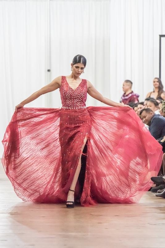 Model in a flowing red gown at the 2022 Le Pasefika Runway show