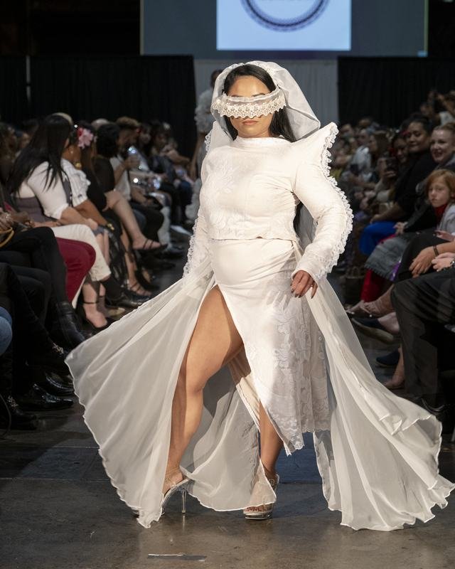 Model in a flowing white gown at the 2024 Le Pasefika Runway show