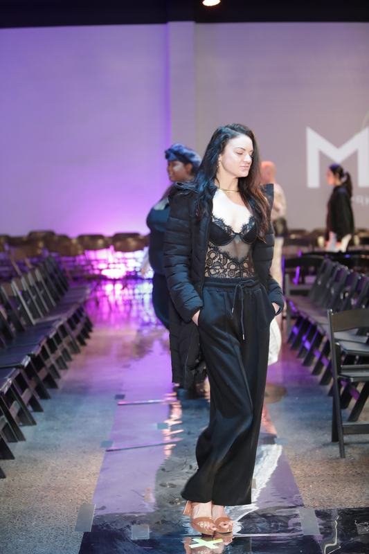 Model walking the glossy runway at the 2025 Le Pasefika Runway show