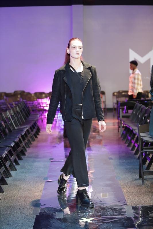 Model in black walking the 2025 runway