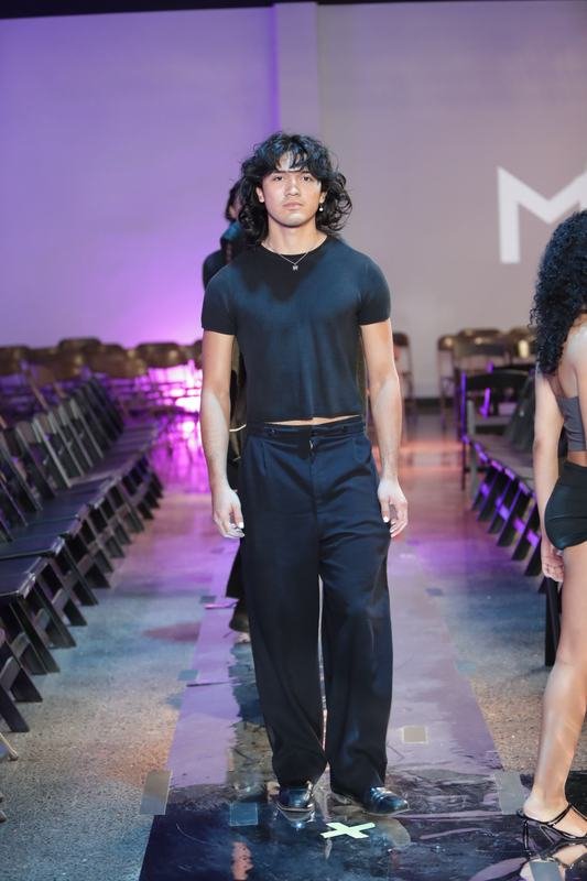 Model in black on the glossy 2025 runway